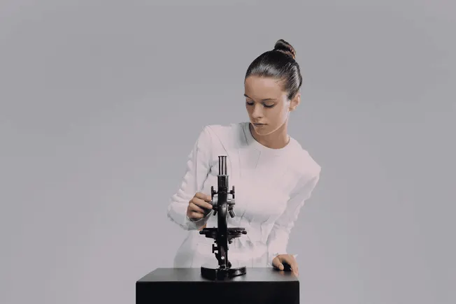 Microscope scientist examining samples for research and analysis at laboratory, healthcare, or biotech facility - Hypebot.