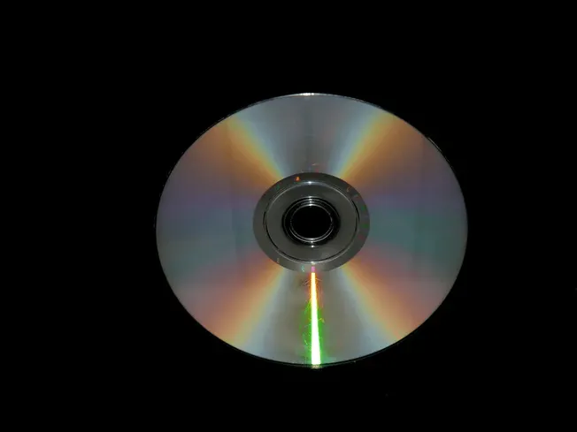 High-quality audio CD with reflective surface, set against black background, showcasing digital music technology and multimed