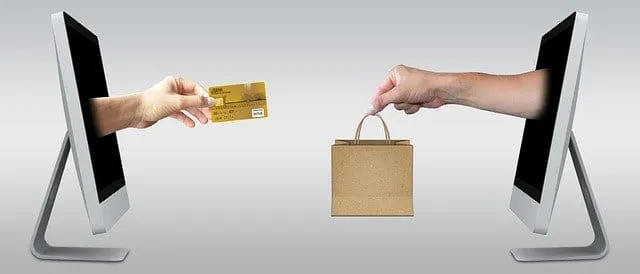 Online shopping transaction between two computer screens showing credit card and shopping bag, e-commerce, digital marketplac