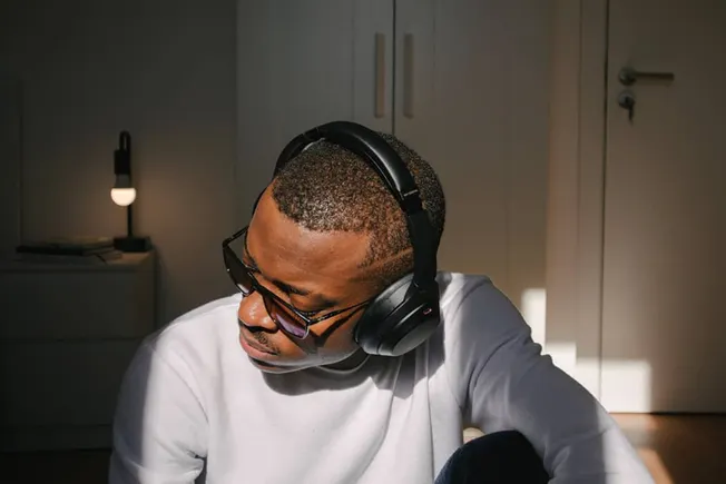 Headphones-wearing-man-in-studio-or-home-environment-for-music-production or listening-to-music-for-creative-work or sound-en