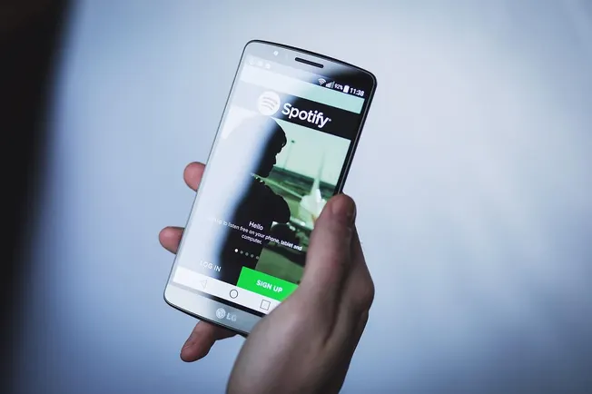 Spotify mobile app on LG smartphone, digital music streaming service, user listening to music on phone, modern music app inte