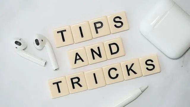 Tips and tricks for music marketing and industry success with headphones, white device, and writing tools on light background
