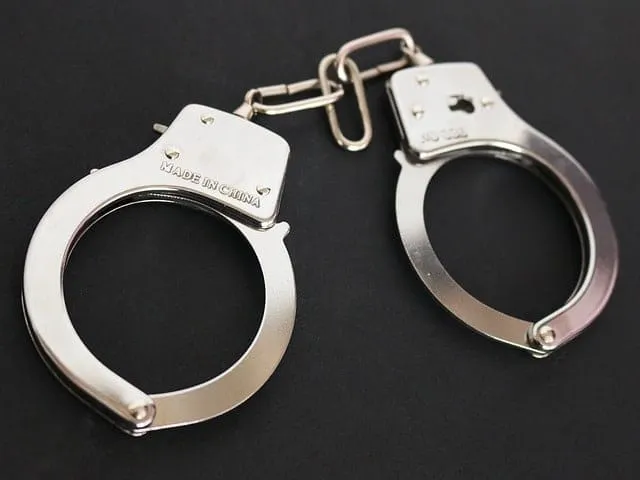 Handcuffs, silver metal police handcuffs on black background, law enforcement gear, crime prevention, security equipment, pol
