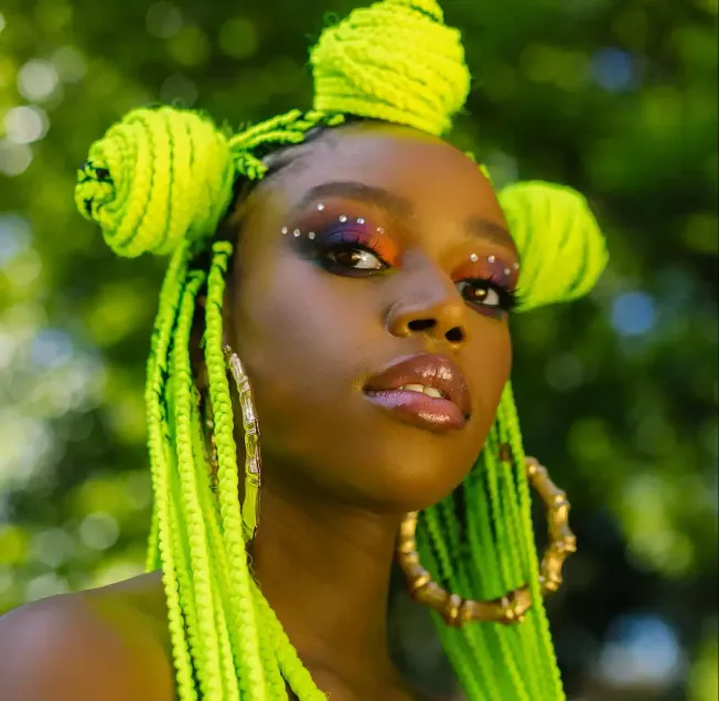 Vibrant neon green braided hairstyle with decorative beads and makeup, showcasing bold jewelry and artistic beauty look, set