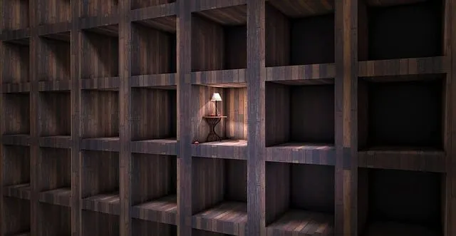 Empty wooden shelving unit with a single lit lamp in one compartment, creating a warm and cozy ambiance.