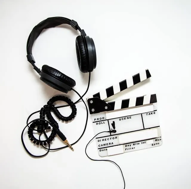 Headphones and film slate on white background for music and video production.