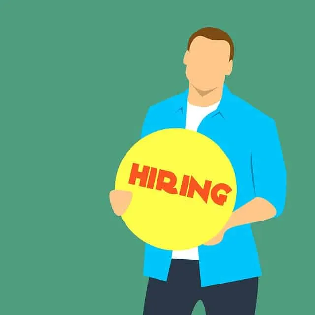 Man holding a yellow circle with "HIRING" text, representing job recruitment and employment opportunities.