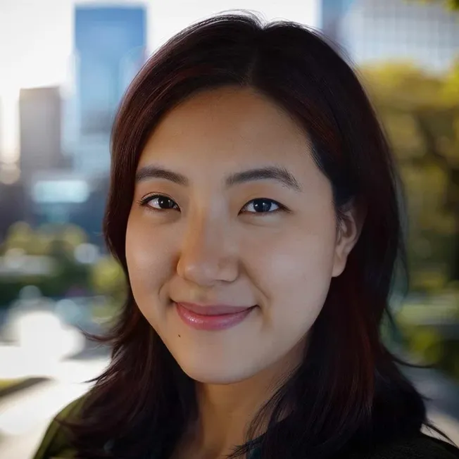 Young Asian woman smiling outdoors in city park, natural lighting, close-up portrait emphasizing beauty and confidence for li