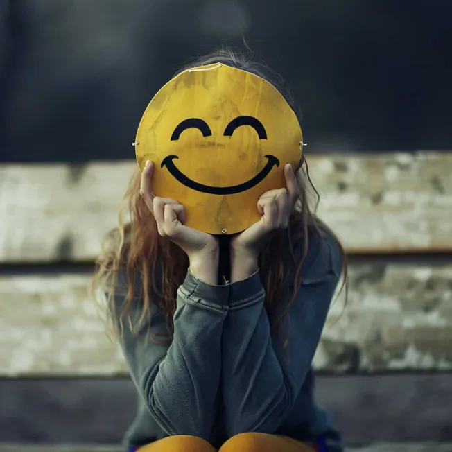 Smile face mask held by woman with long hair, urban background, social media, online communication, digital art, emotion expr