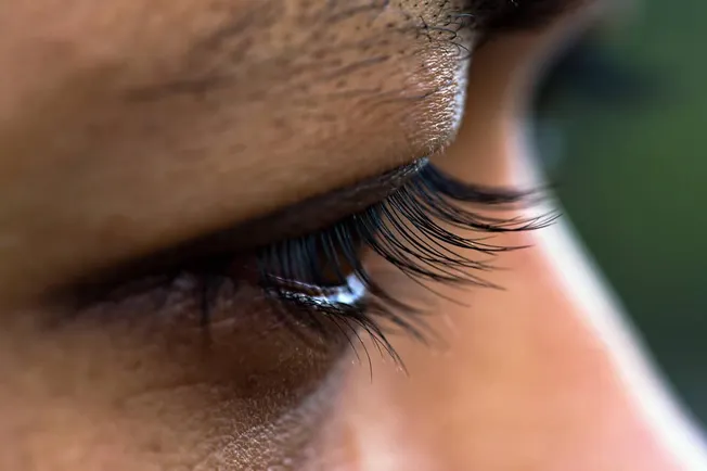 Close-up of a person's eye with detailed eyelashes and skin texture, highlighting beauty and skincare focus for social media