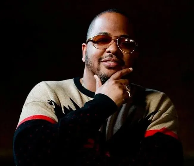 Someone thinking creatively, wearing sunglasses and a casual sweater, with a confident expression, symbolizing innovative ide
