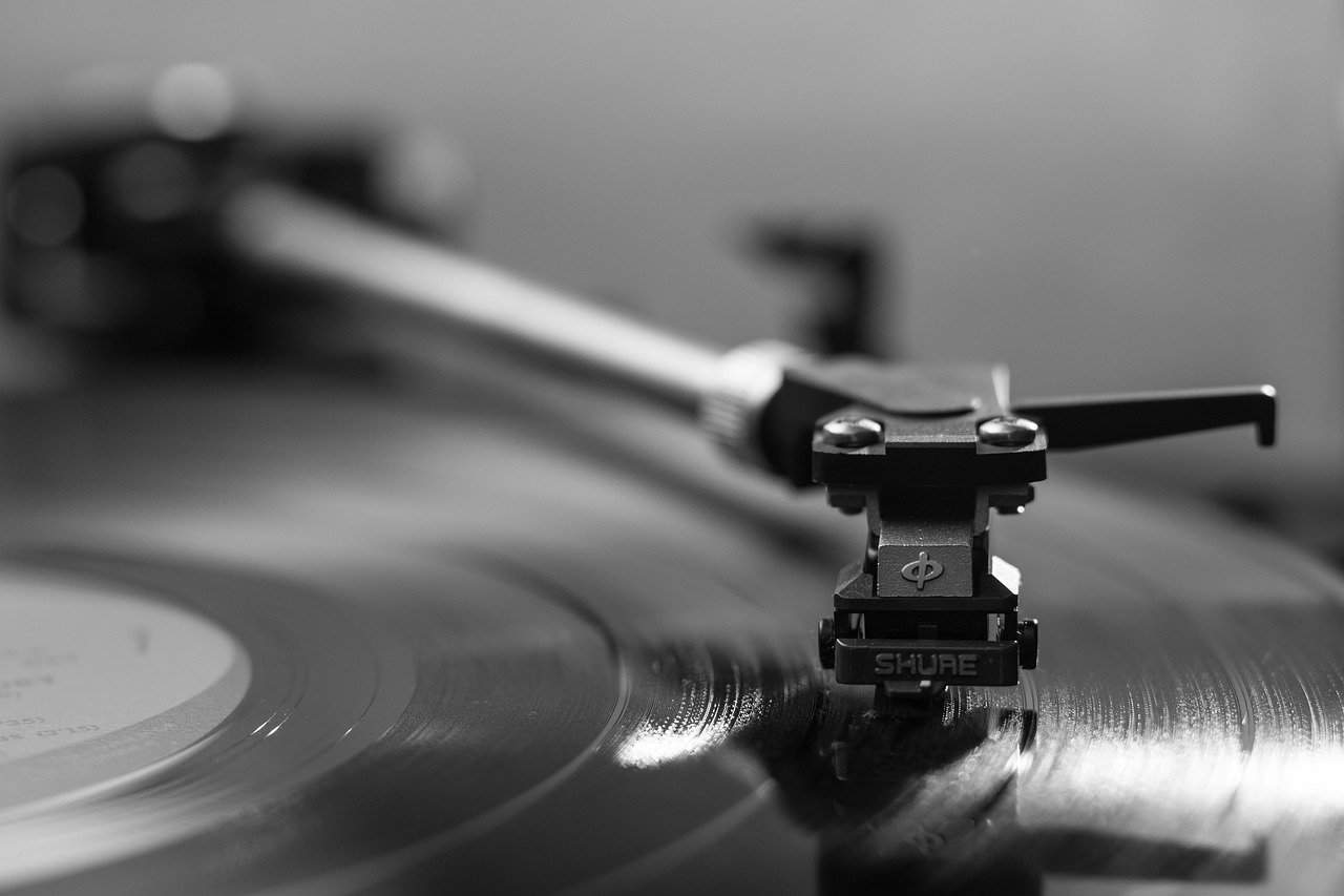 Studio recording turntable with vinyl record, DJ equipment and music production setup for DJing and music mixing, black and white image emphasizing sound and music technology, Hypebot music industry news and insights.