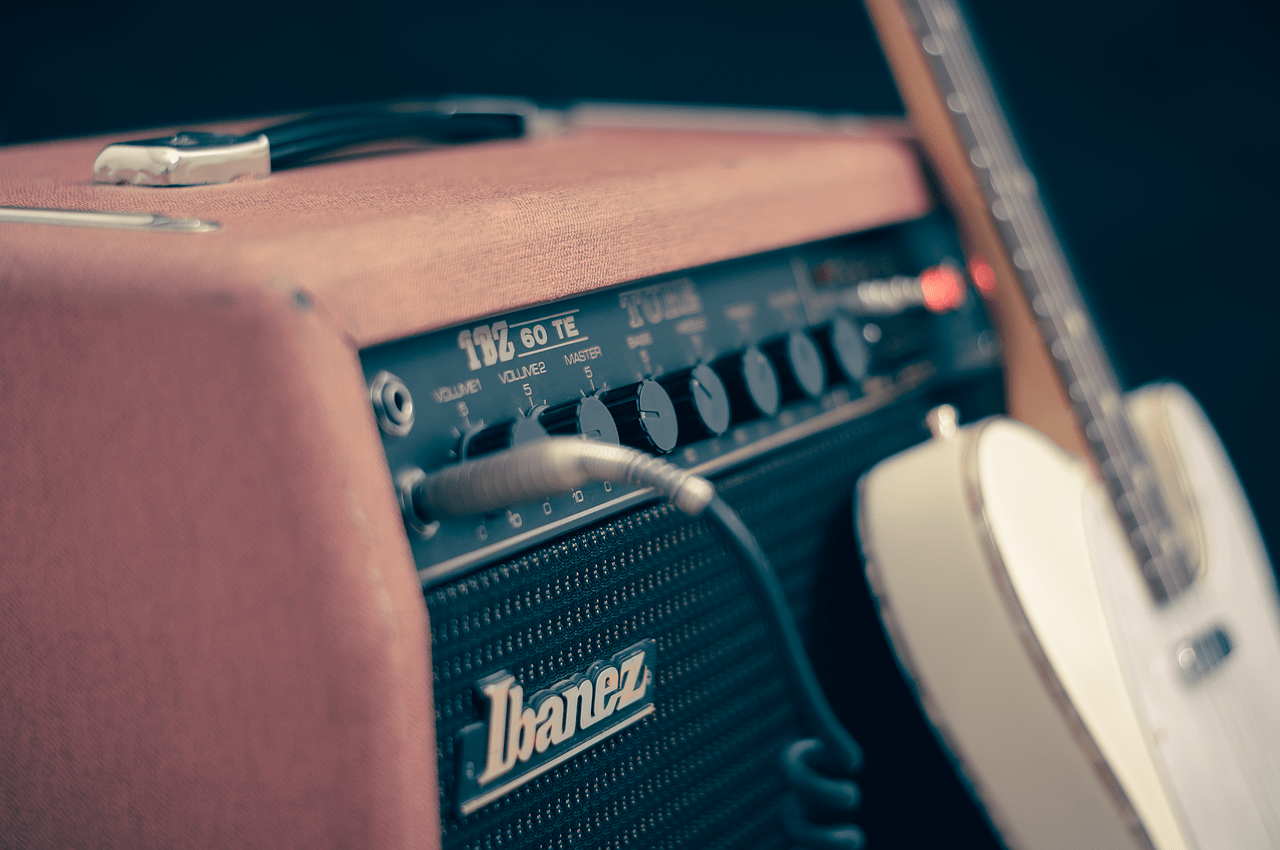 Guitar amplifier and acoustic guitar close-up, music equipment for live performance or recording, essential tools for musicians, emphasizing sound quality and music production.
