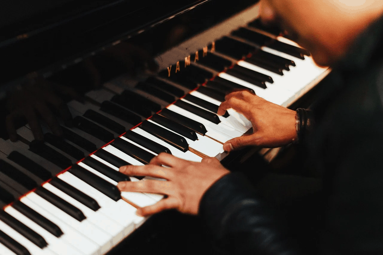 Piano keyboard playing hands music performance black and white keys close-up.