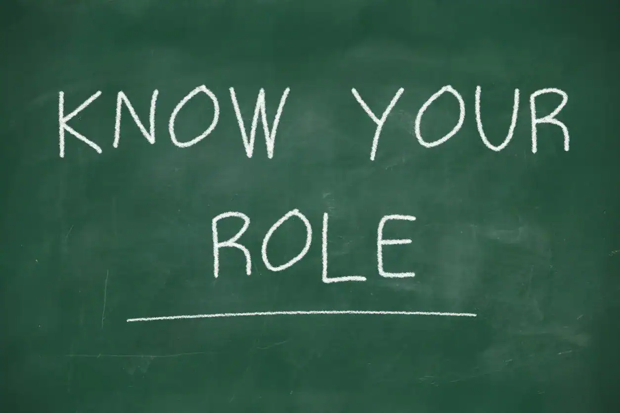 Knowing your role written on a green chalkboard with white chalk text.