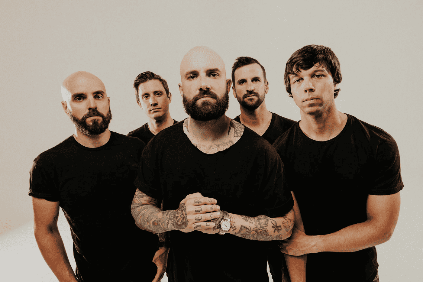 Arock band members with tattoos and serious expressions in a promotional photo, emphasizing music industry, band promotion, and musician branding.