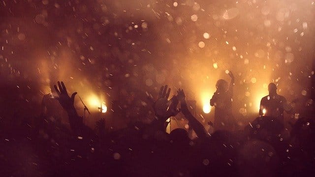 Concert crowd enjoying live music on stage with vibrant lighting and energetic atmosphere at a music event.