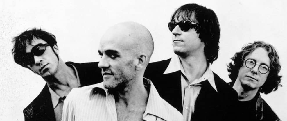 A black and white photo of four band members with sunglasses, showcasing a classic rock aesthetic; ideal for music industry articles and entertainment websites.