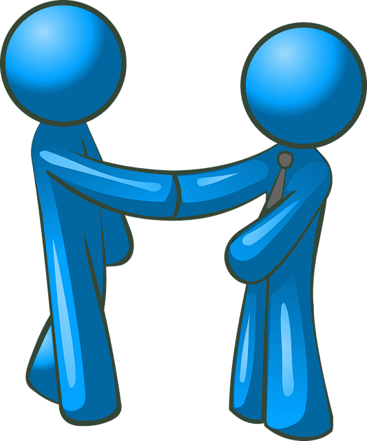 Colleagues shaking hands in a professional setting, symbolizing collaboration or agreement.