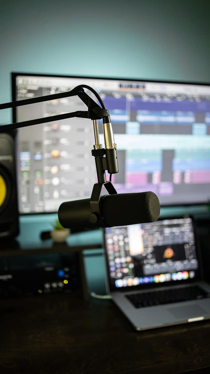 High-quality podcasting microphone setup with music production software on a computer screen, ideal for music, radio, or content creation.