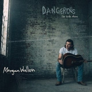 Moody artist portrait of Morgan Wallen with guitar against gritty brick wall, promotional music album cover for Dangerous, country music artist, authentic musician vibe, music release artwork.