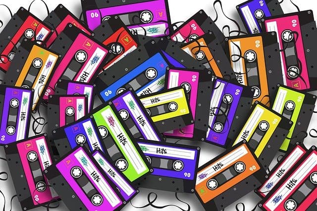 Red, blue, green, yellow, purple, orange vintage audio cassette tapes, music recording, retro media, nostalgic sound media, tape recorder, musical expression, analog recording, cassette collection, music industry, vintage audio equipment.