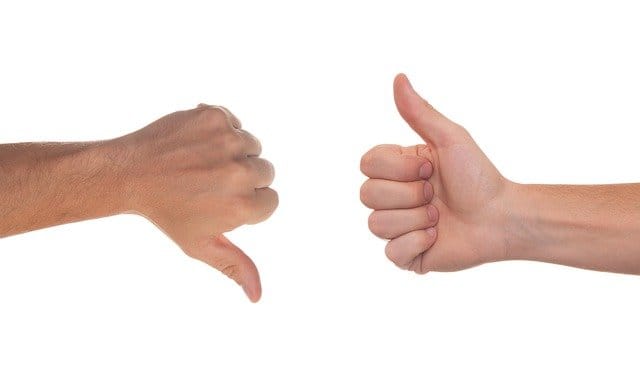 Arm and hand giving thumbs down and thumbs up signs, positive and negative feedback, social media expressions, communication gestures, sign language, approval and disapproval in digital content.