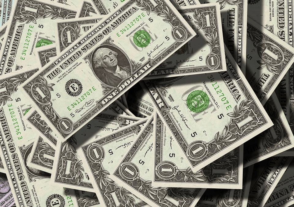$1 bills scattered in a pile, symbolizing money, cash flow, and financial transactions.