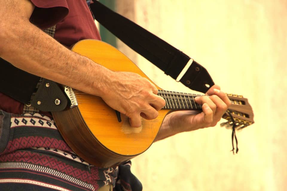 A person playing an acoustic guitar with focus on hands and instrument, highlighting music, guitar playing, and musical performance.
