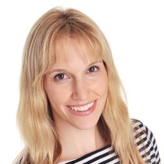 A smiling woman with blonde hair wearing a striped top, modeling for a digital media or music industry image.