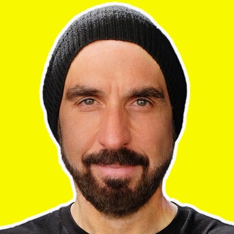High-quality image of a man wearing a black beanie with a bright yellow background, emphasizing modern digital media and music industry relevance for Hypebot readers.