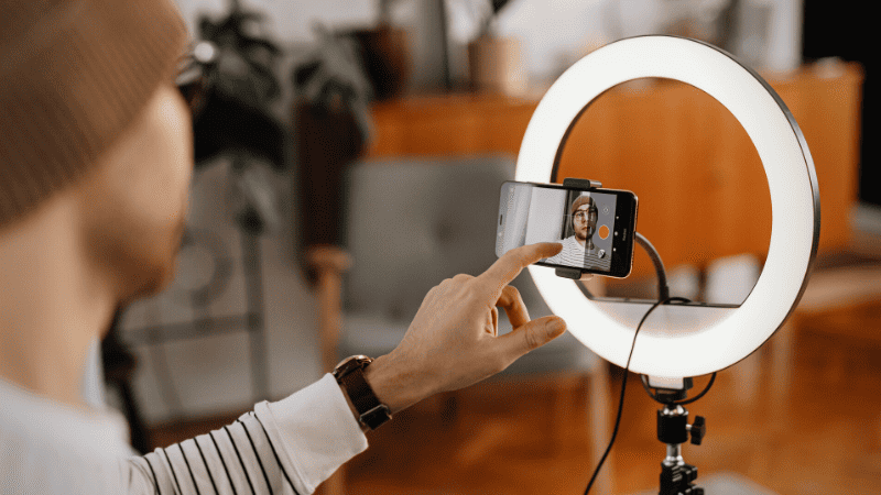 Selfie taken with ring light and smartphone for content creation or streaming.