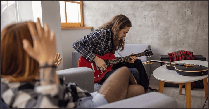 Electric guitarist practicing at home, music practice session, casual jam room, creative musician, guitar skills development, music studio setup, home music environment.
