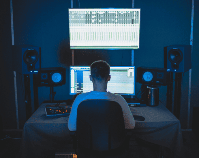Ableton Live music production studio with digital audio workstation in use, music producer working on a project at night, surrounded by studio monitors and DJ equipment, showcasing modern music creation.