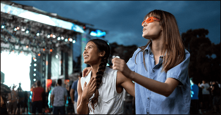 Festival music concert outdoor event fun summer teenagers dancing and enjoying live music at a city festival atmosphere vibrant entertainment engaging crowd.