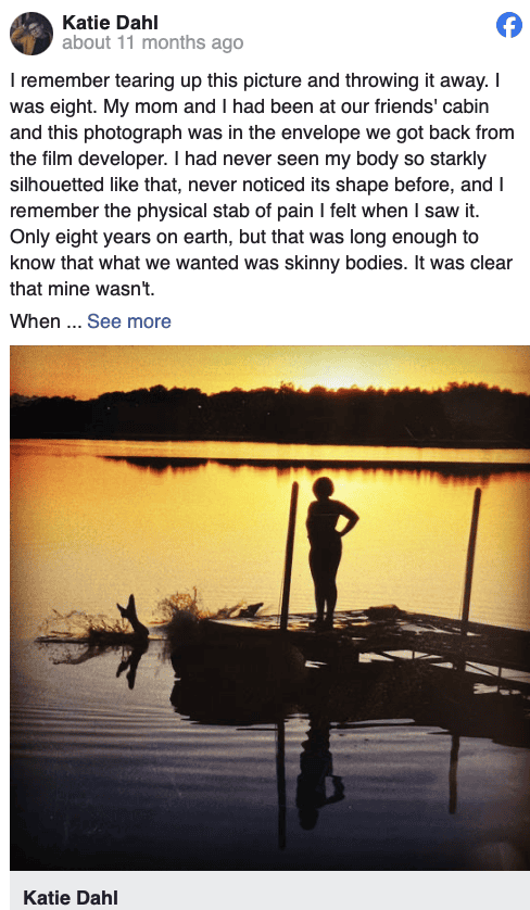 Sunset over a lake with silhouette of a woman standing on a dock, peaceful reflection, warm orange sky, serene outdoor scene, calm waters, nature photography, tranquil moment, relaxing landscape, scenic view, Hypebot music industry imagery, artistic outdoor photography, emotional landscape shot, peaceful evening setting.