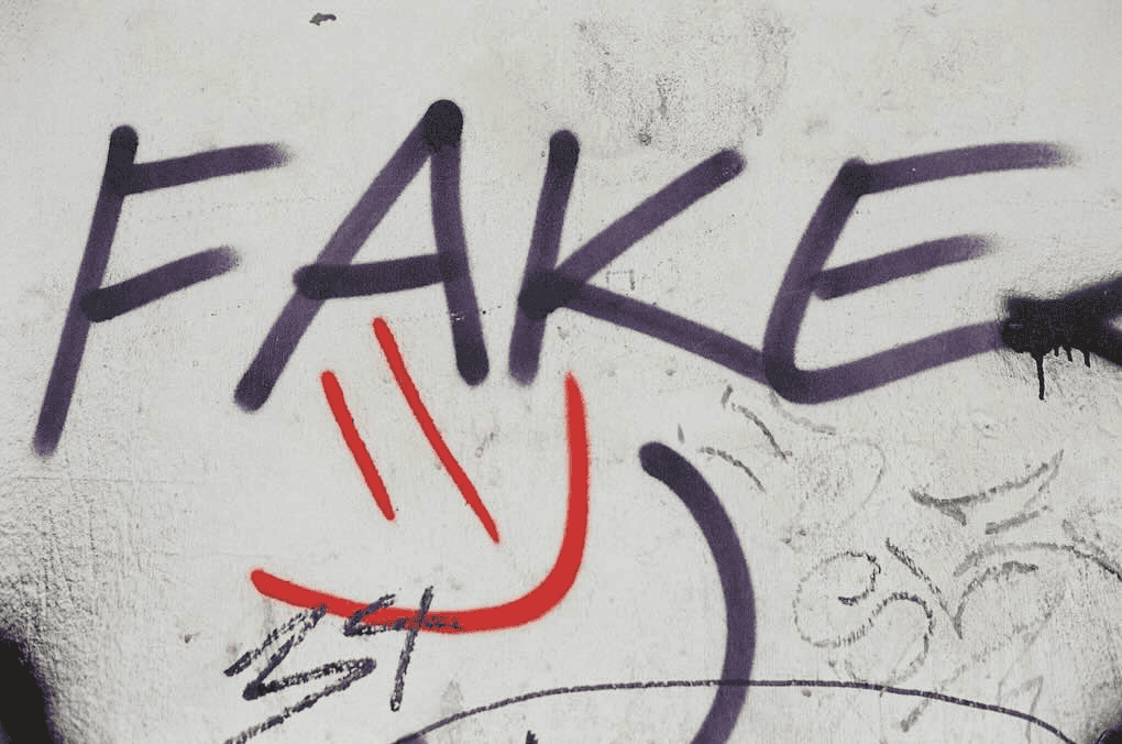 Fake graffiti on a wall with bold purple and red spray paint, highlighting street art and urban culture themes.