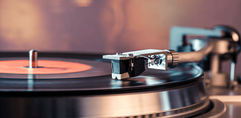 A high-quality image of a vintage turntable playing a vinyl record, perfect for music industry articles, DJ gear reviews, or audio technology content.