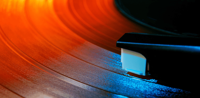 Vinyl record spinning on turntable with colorful lighting, music industry, entertainment, audio technology, DJ equipment, music production, Hypebot, digital media trends, music business analysis, recording technology.