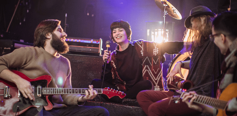 Young musicians performing live music in a vibrant indoor concert setting at Hypebot.