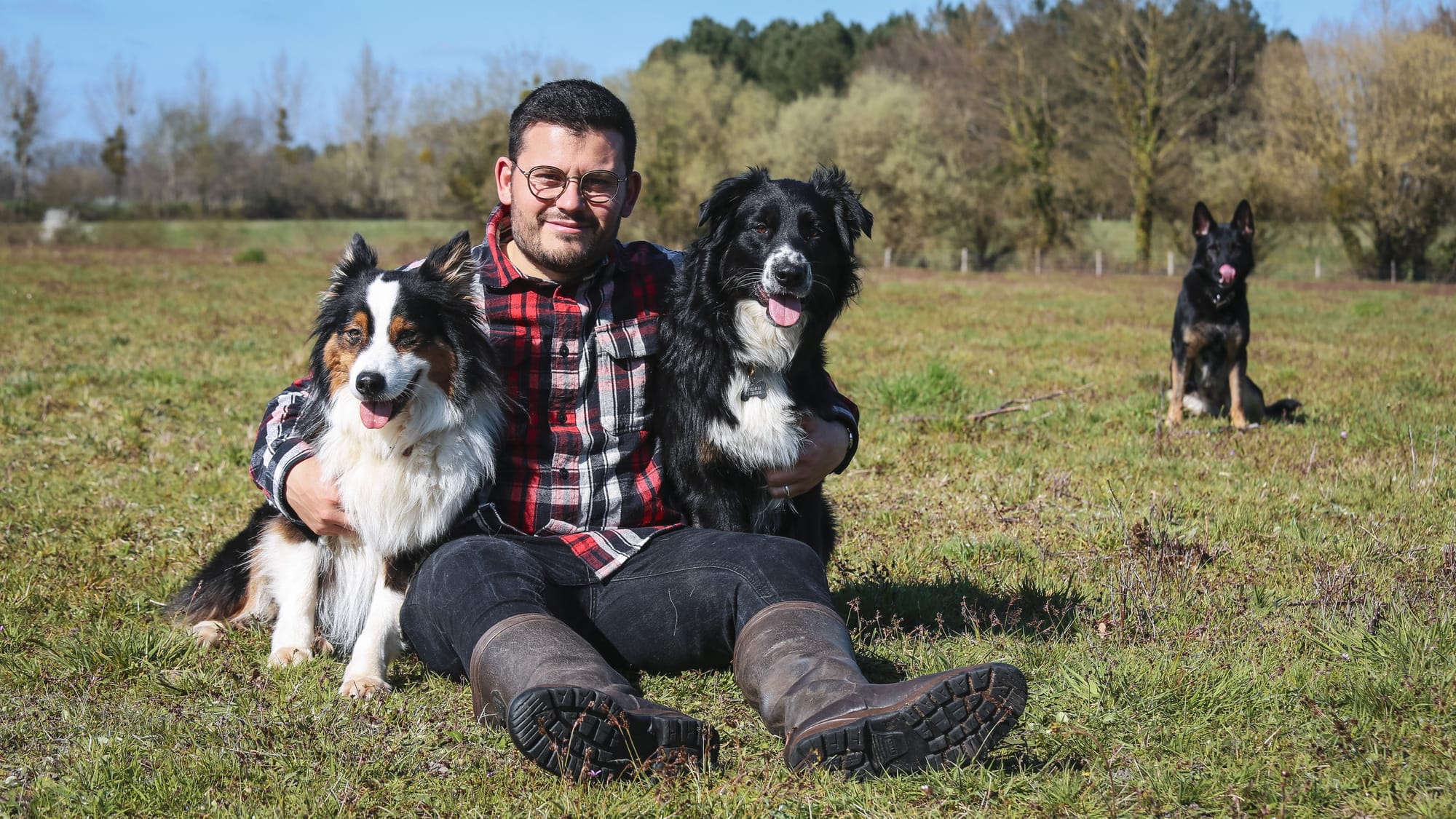 pierre et ses trois chiens, un berger allemand, un berger australien de travail et un berger australien de compagnie