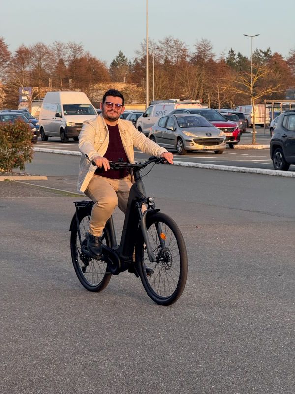 pierre sur un vélo électrique et sur un parking