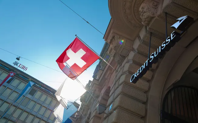 Swiss flag beside the Credit Suisse sign on a Zurich building