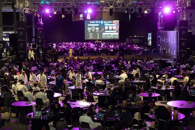 Packed conference hall under purple lights at a cybersecurity event