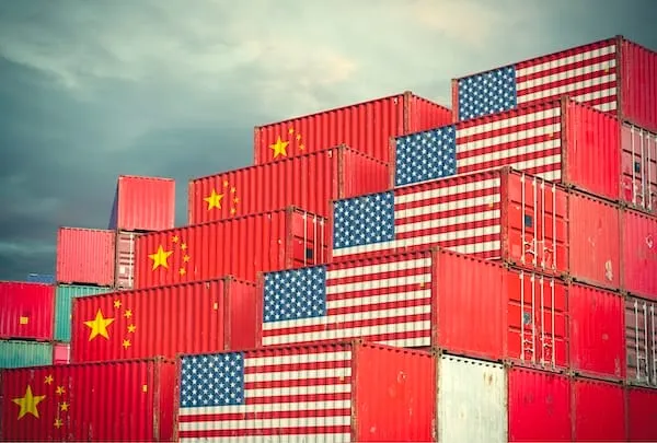 Shipping containers stacked high, painted with US and Chinese flags
