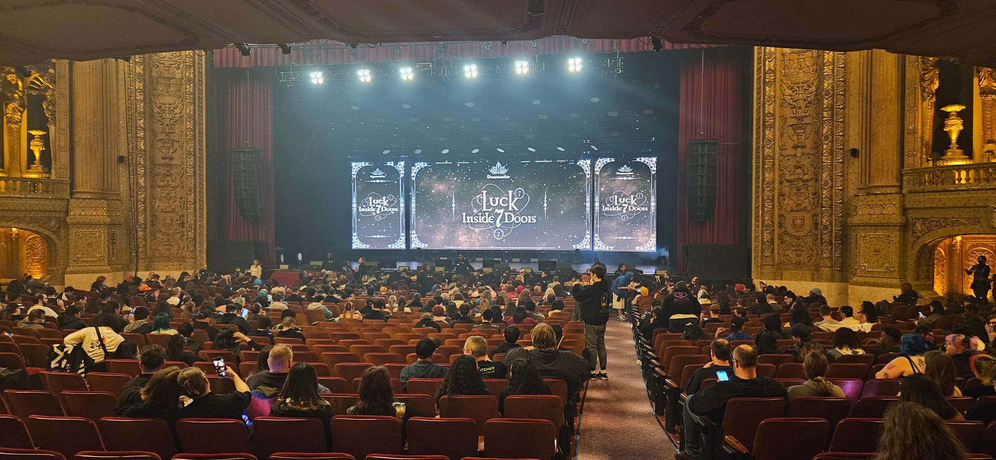 Back of the room shot of the Chicago Theatre, showing Luck Inside 7 Doors Dreamcatcher on a backing screen.
