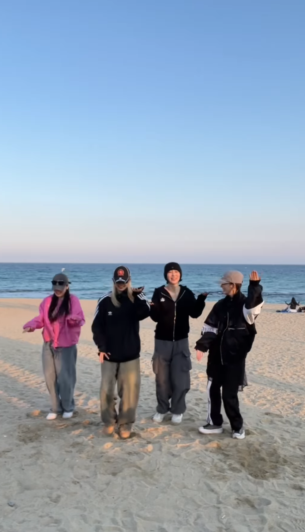 Dami with friends dressed in black and pink doing a dance.