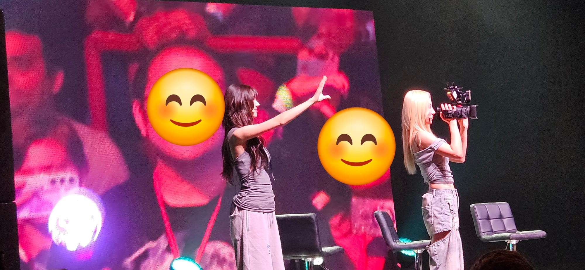 Yoohyeon waves to the crowd as SuA holds a camera and focuses in on a fan for JiU.