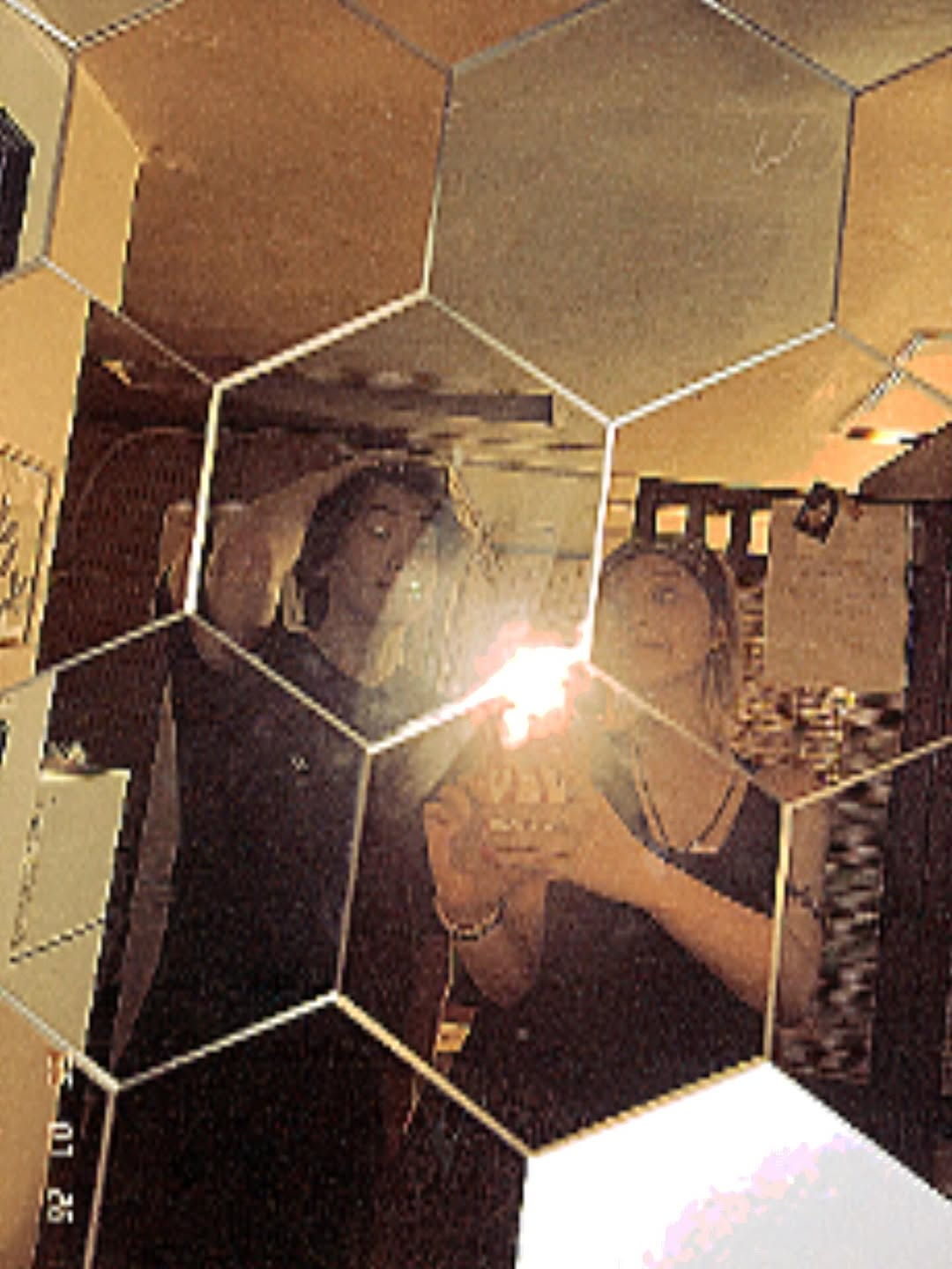 Siyeon and a fellow band member take a grainy photo in front of a mirror.