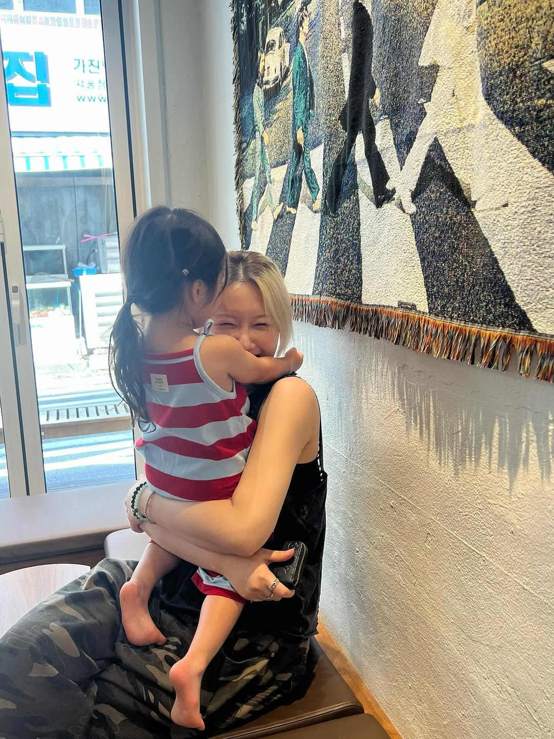 Siyeon smiles while holding her niece in her arms.